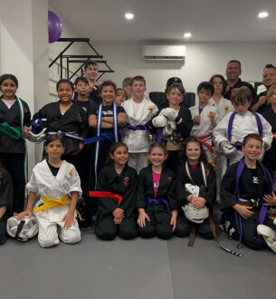 Kids martial arts class at Johnny Karate NYC with students in uniforms and instructors.