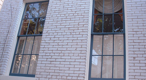 Restoration of historic masonry and tuckpointing on a brick building facade.