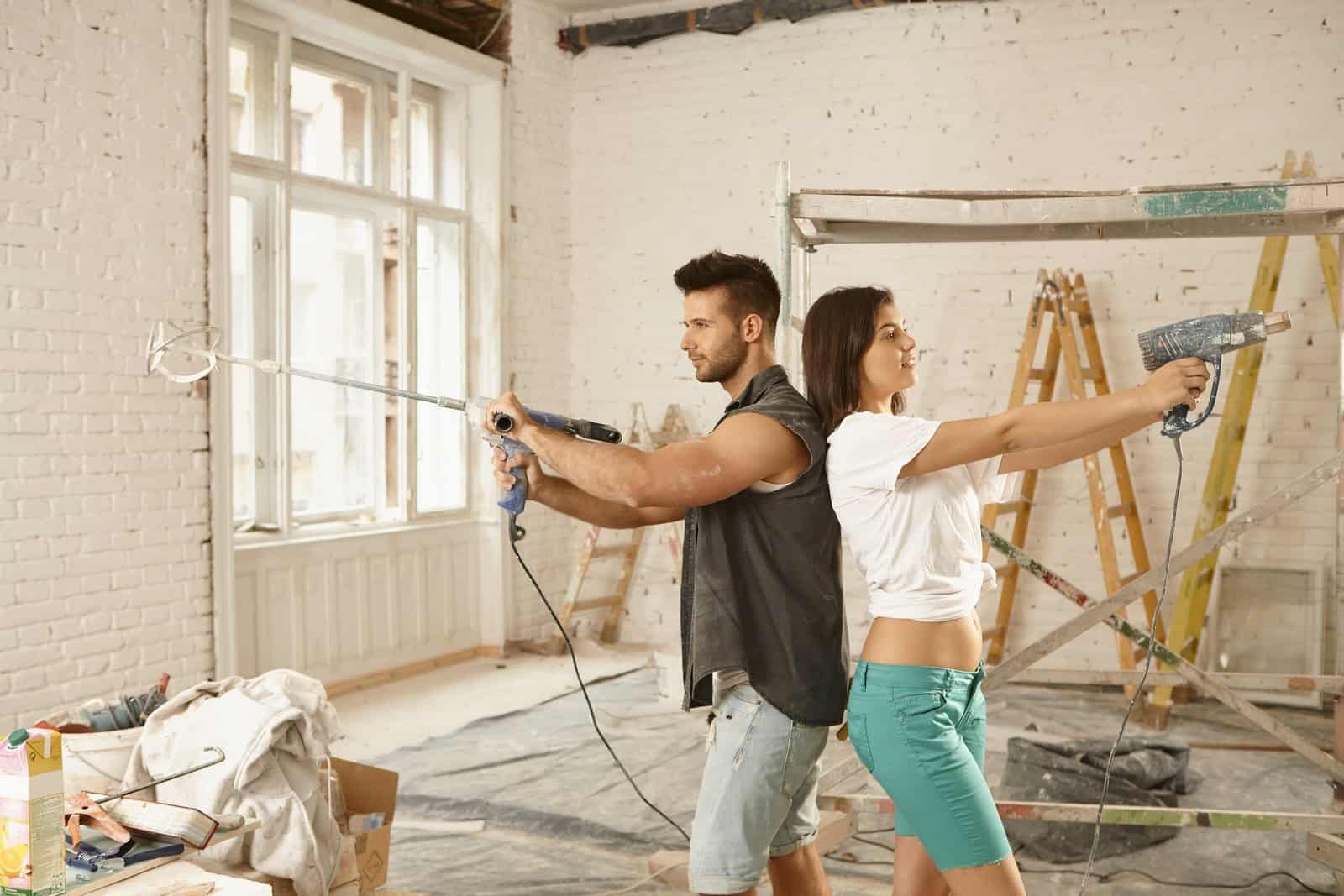 Two workers performing masonry and tuckpointing on a historic brick building.