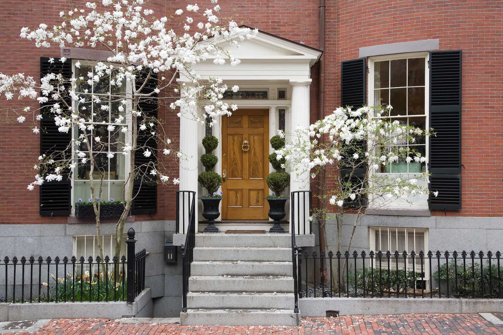 Historic brick building with well-maintained masonry and decorative black shutters.
