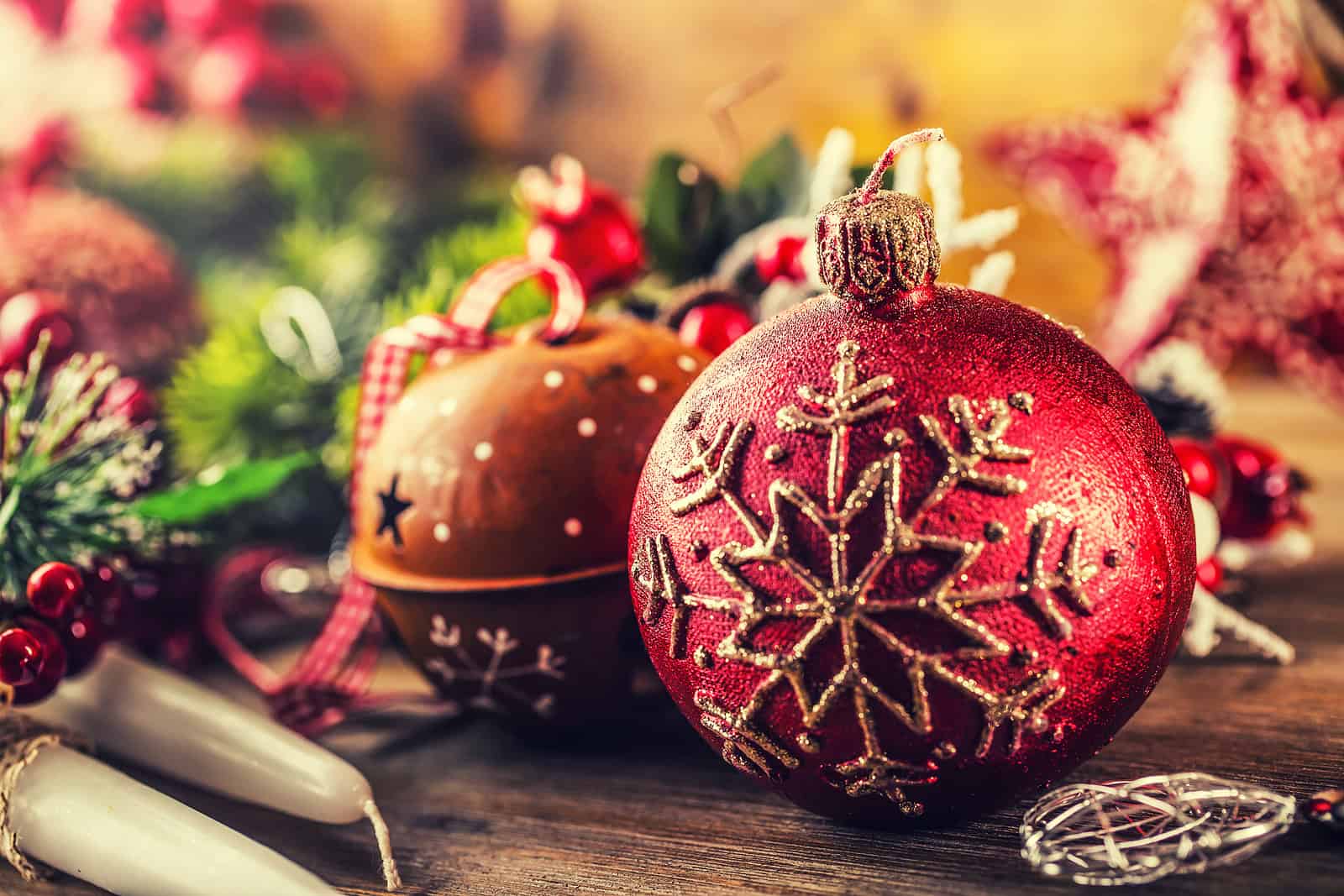Bright red Christmas ornament with gold snowflake design on a festive background.