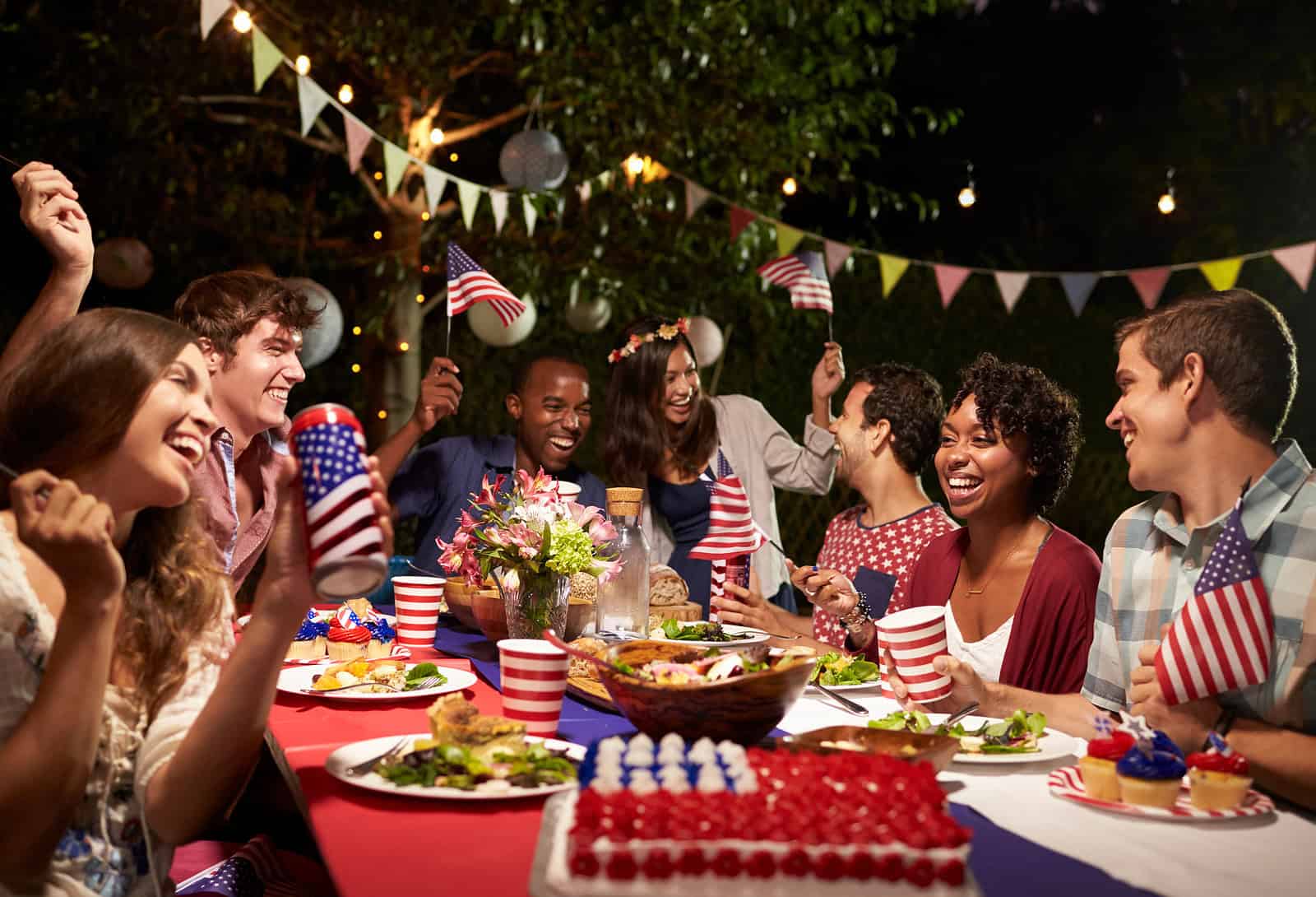 Renaissance Development team celebrating outdoors with American flags and festive decorations.