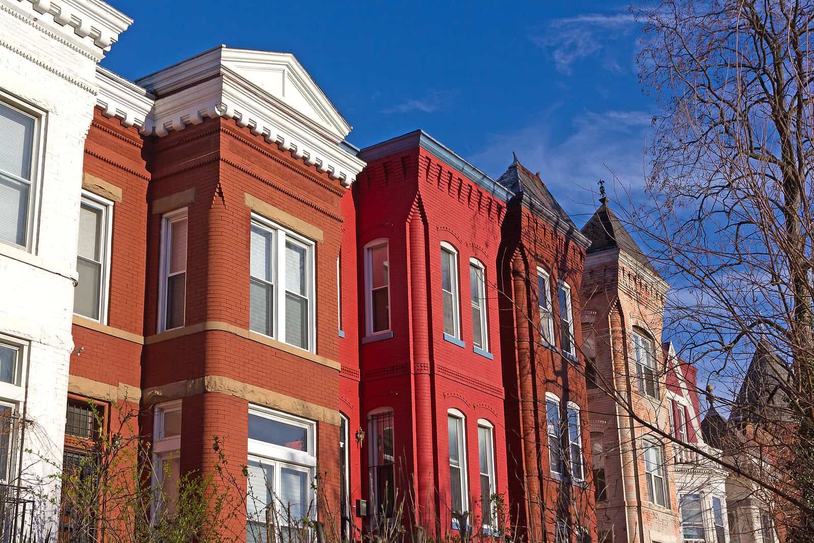 Historic brick row houses with detailed masonry work and tuckpointing in a city neighborhood.