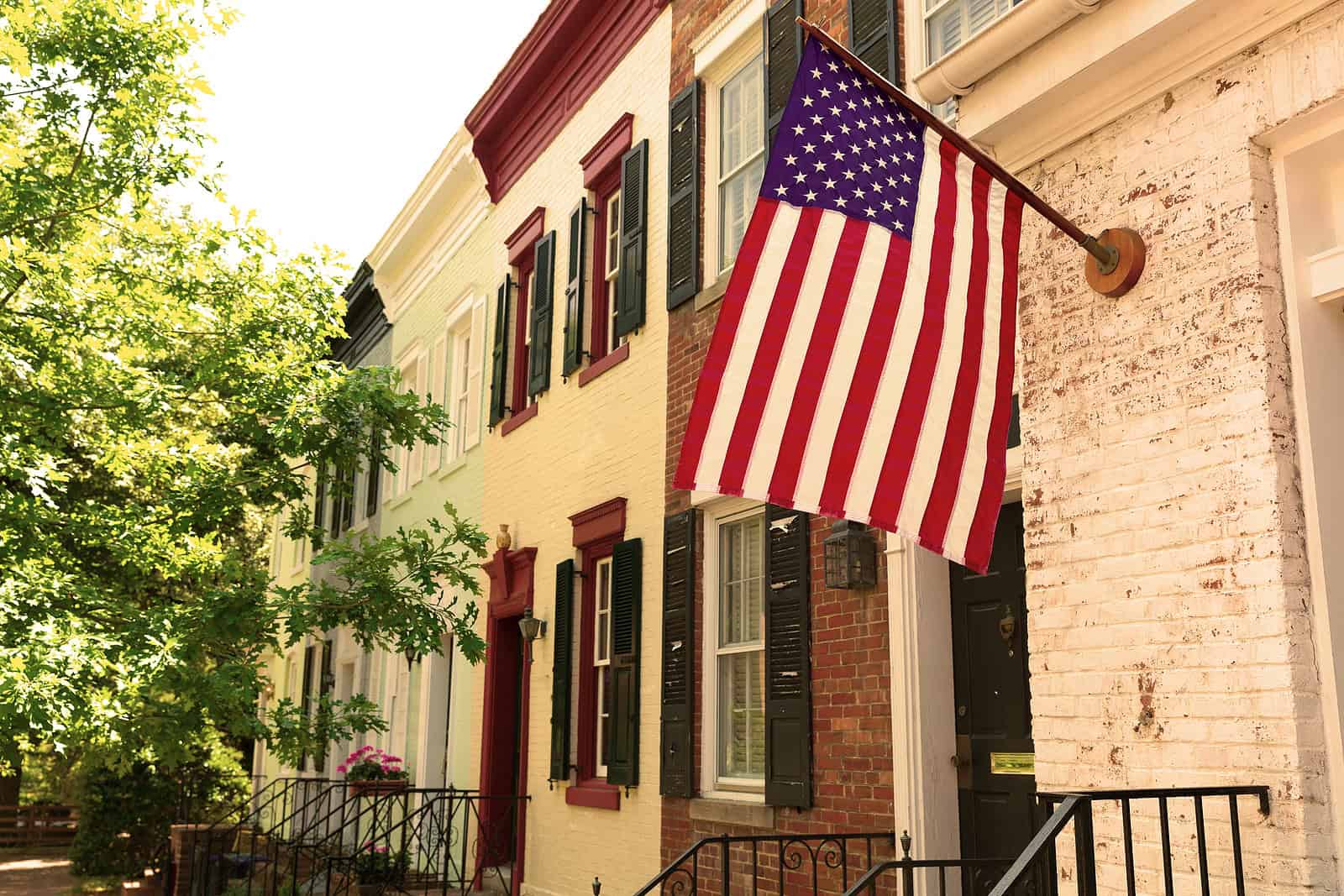 American flag hanging on a historic brick building with detailed masonry work.