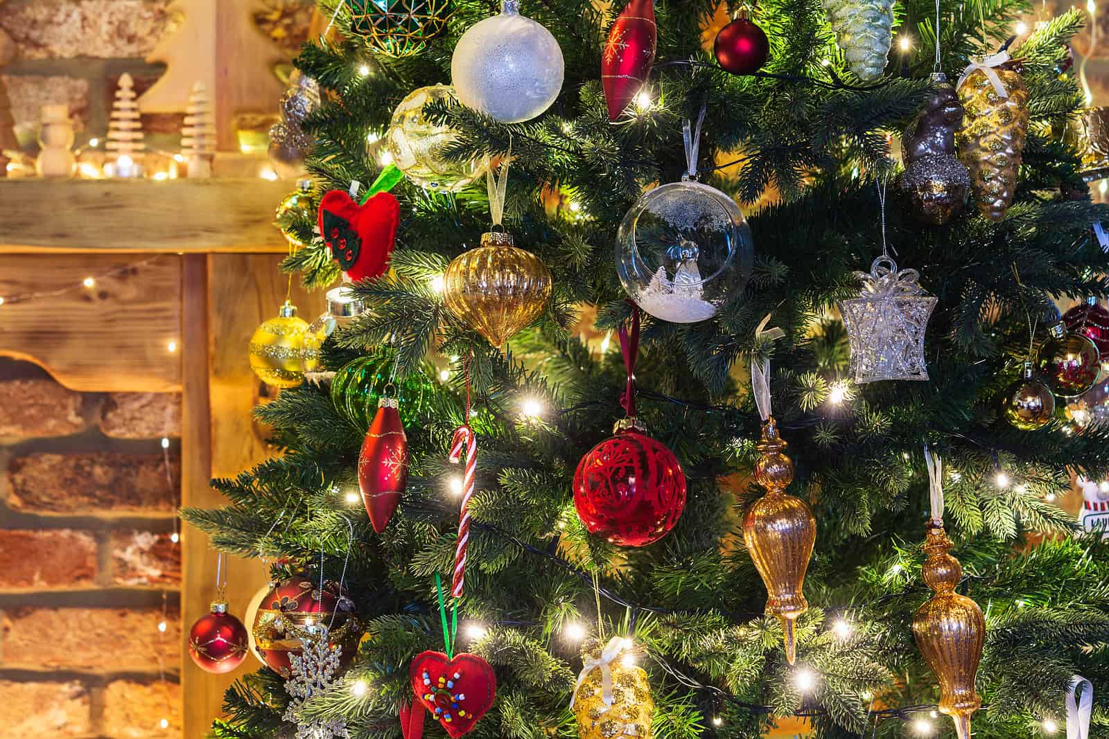Decorated Christmas tree with ornaments and lights in a cozy home setting.