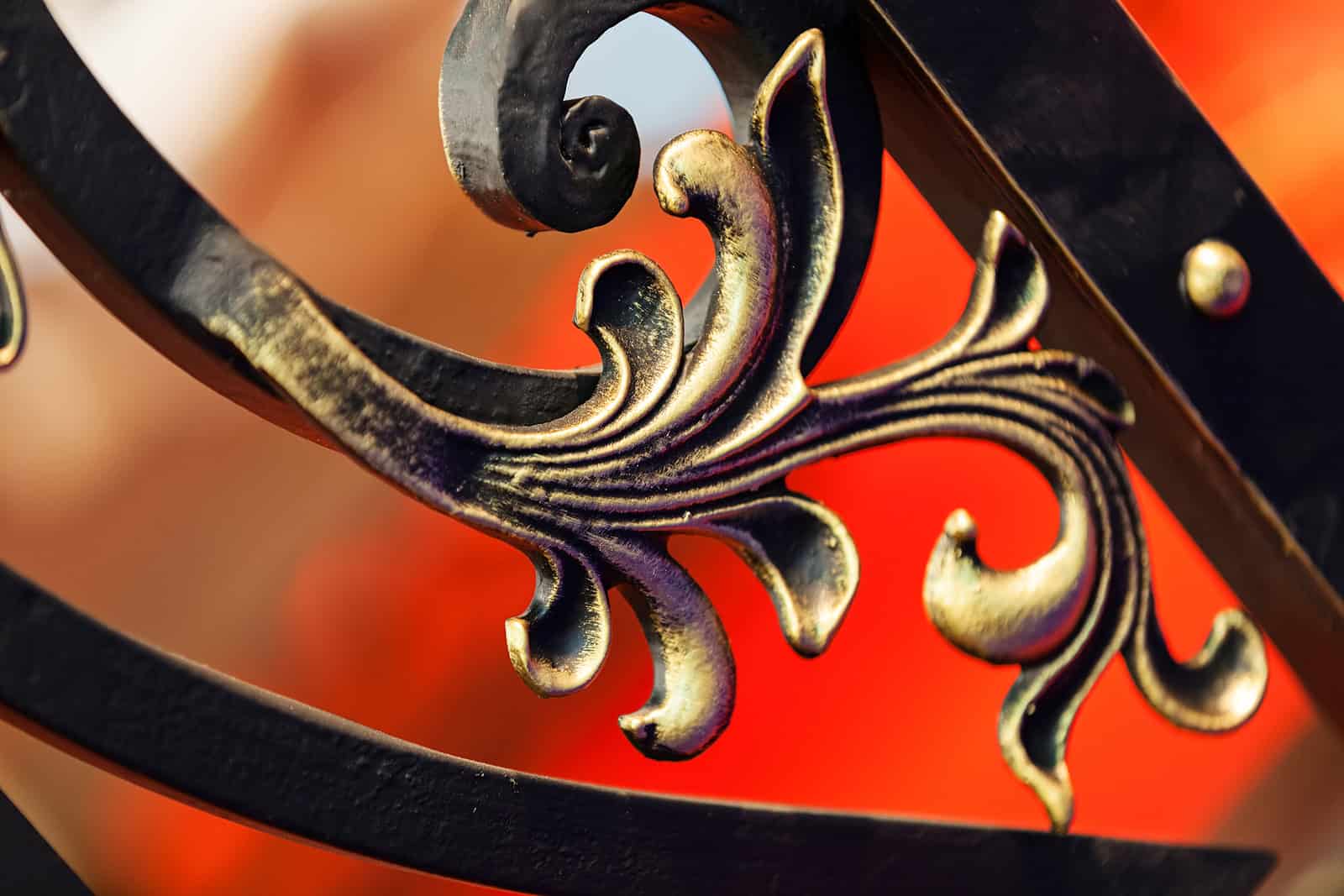 Ornamental ironwork detail with intricate scrolls and gold accents, showcasing craftsmanship in hist.