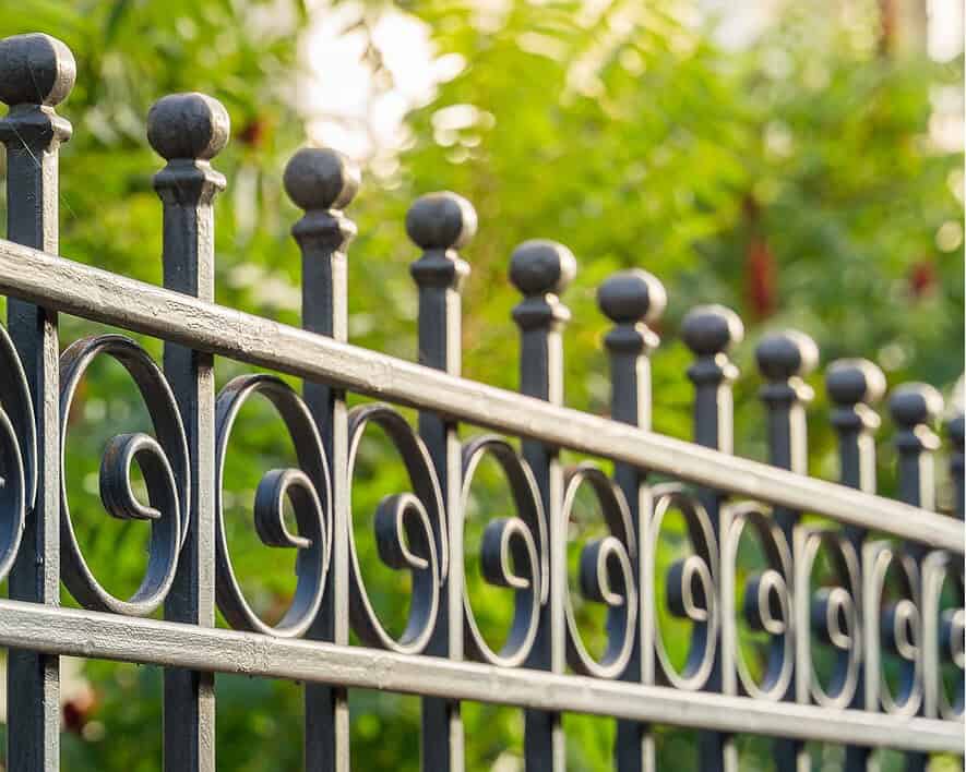 Iron fence with decorative finials and scrollwork, showcasing historic masonry craftsmanship.