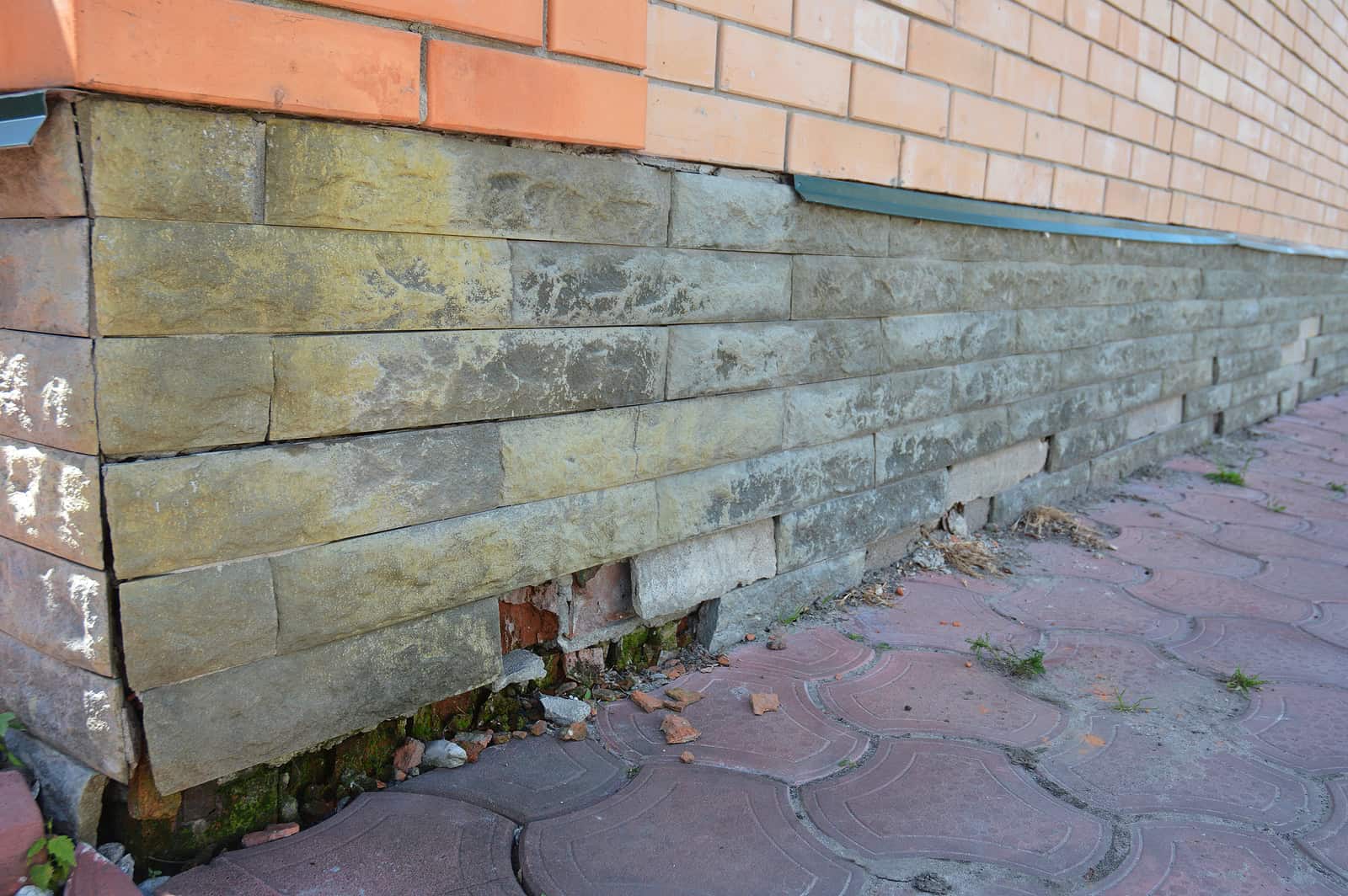 Close-up of historic masonry and tuckpointing work on a brick building's foundation.