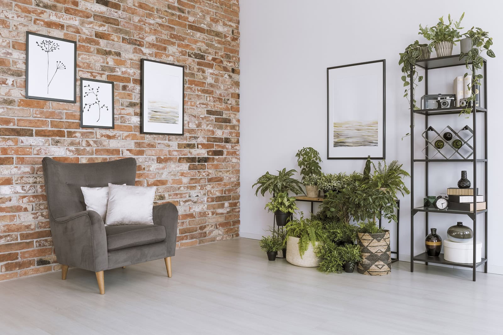 Modern living room with brick wall, artwork, and green plants.