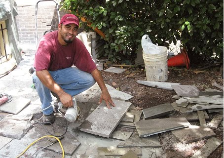 A smiling Renaissance Development worker preparing a site for a patio build.
