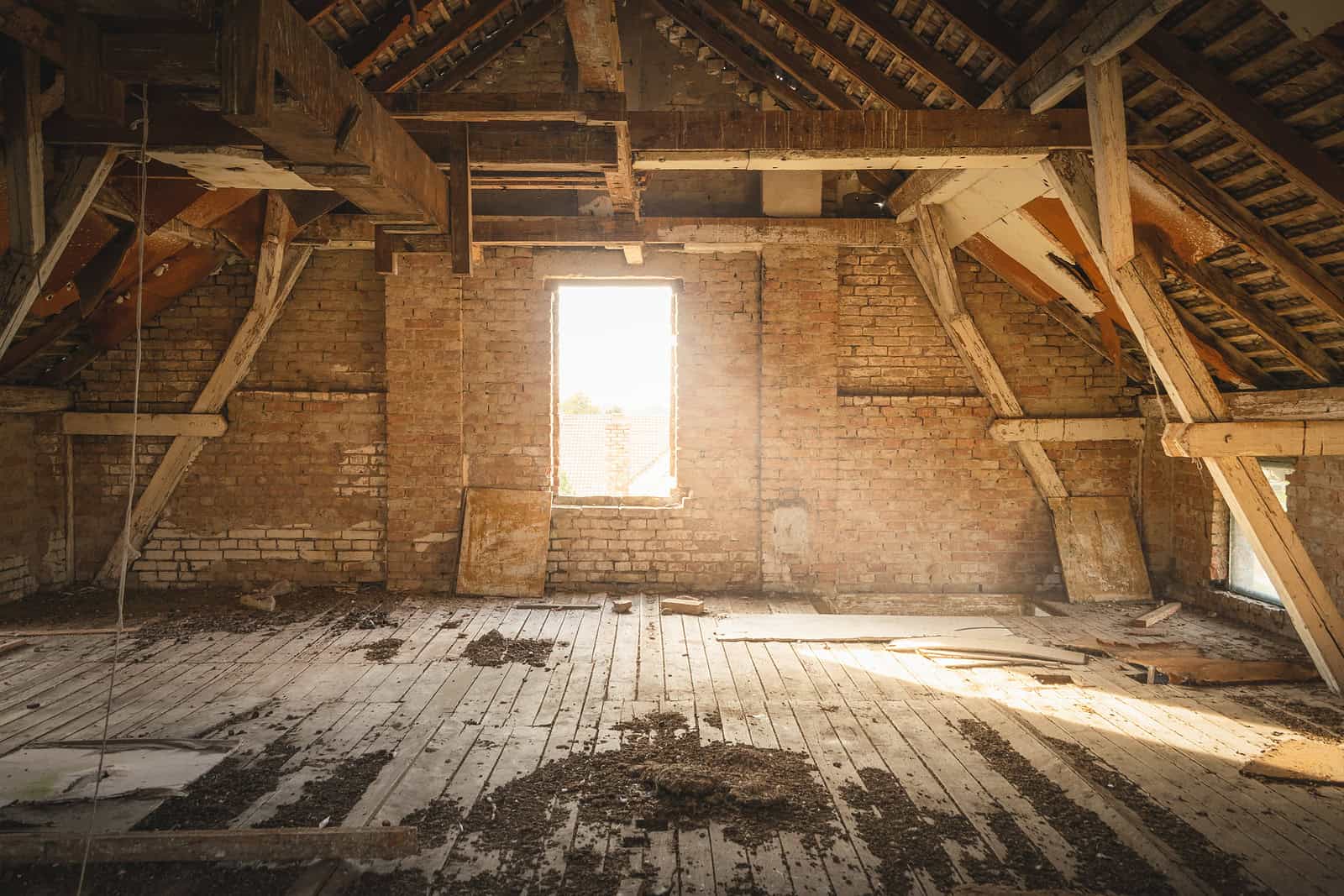 Interior of an old building under renovation with exposed brick and wooden beams.