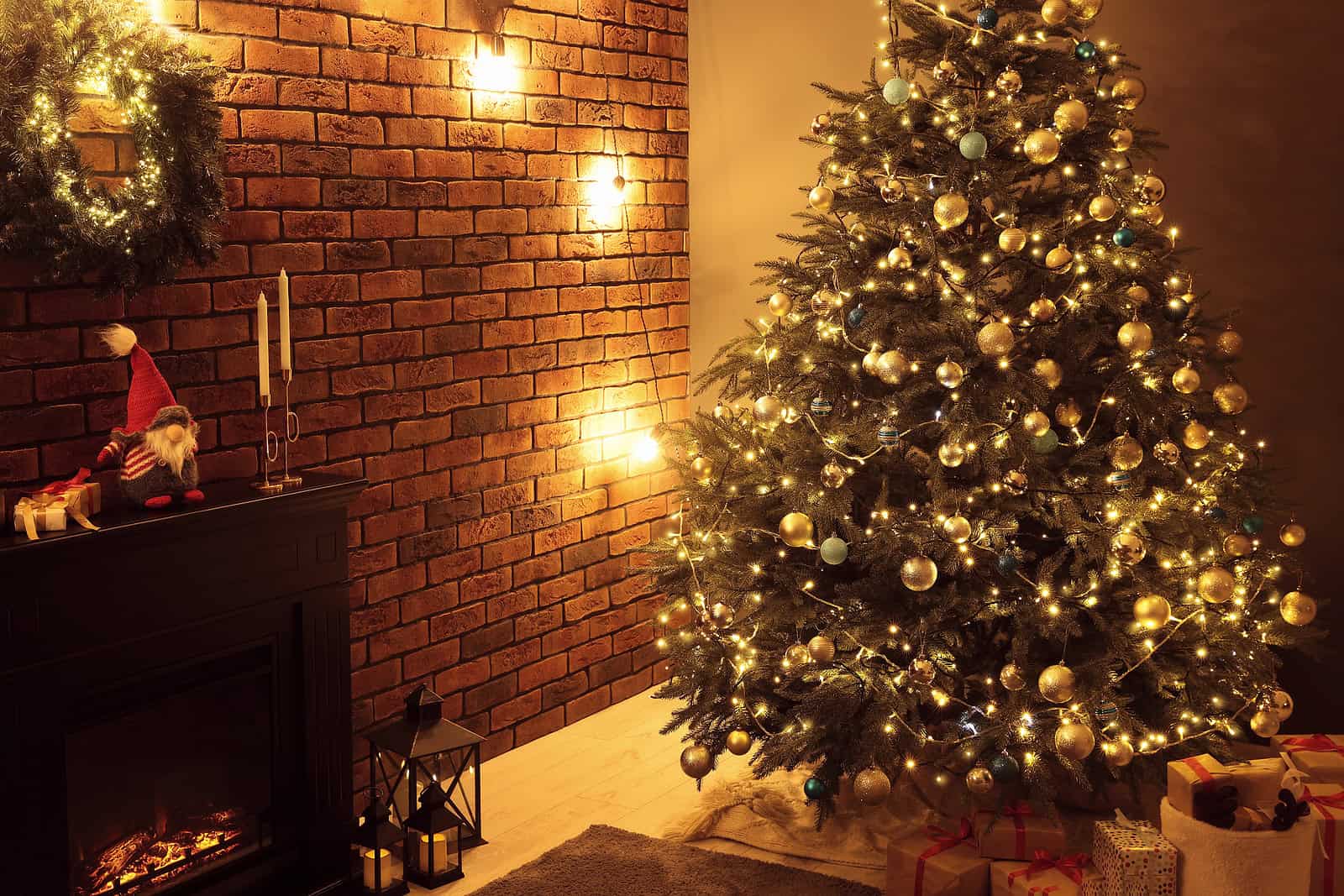 Christmas tree decorated with gold ornaments and lights in a cozy holiday setting.