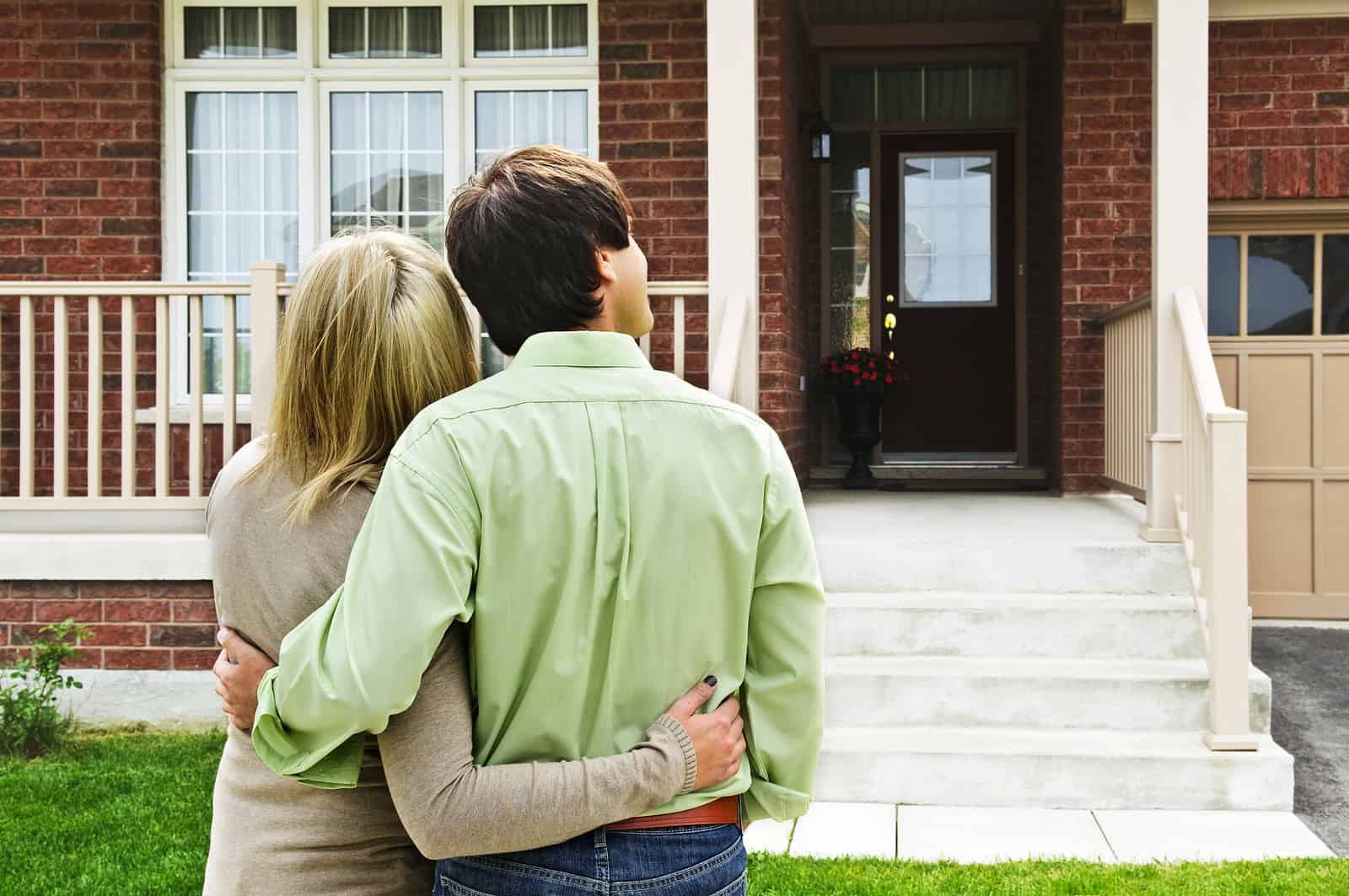Couple viewing a historic brick house with restored masonry and tuckpointing work.
