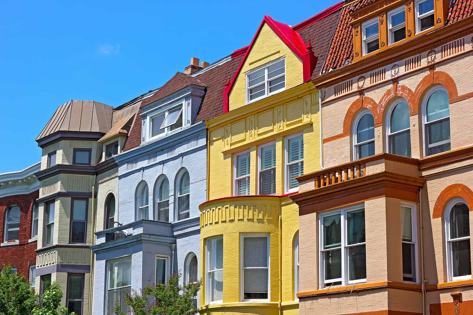 Beautiful row of colorful historic Victorian houses with detailed masonry and tuckpointing work.