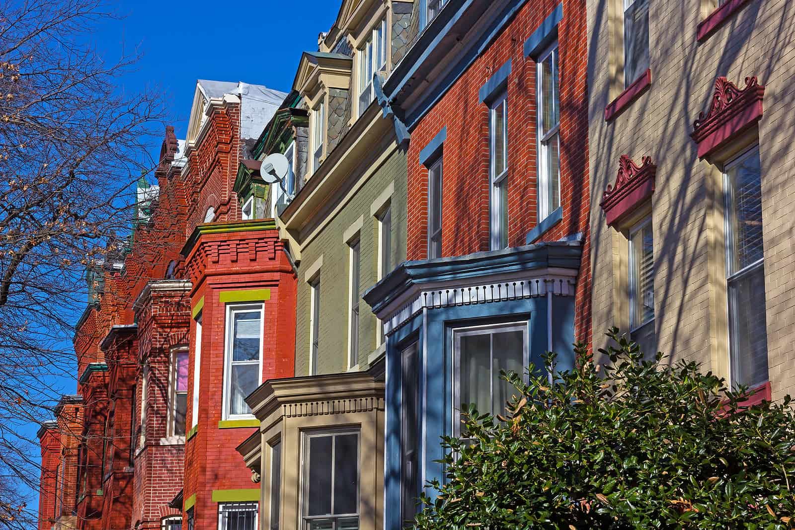 Historic masonry and tuckpointing work on colorful row houses in a city neighborhood.