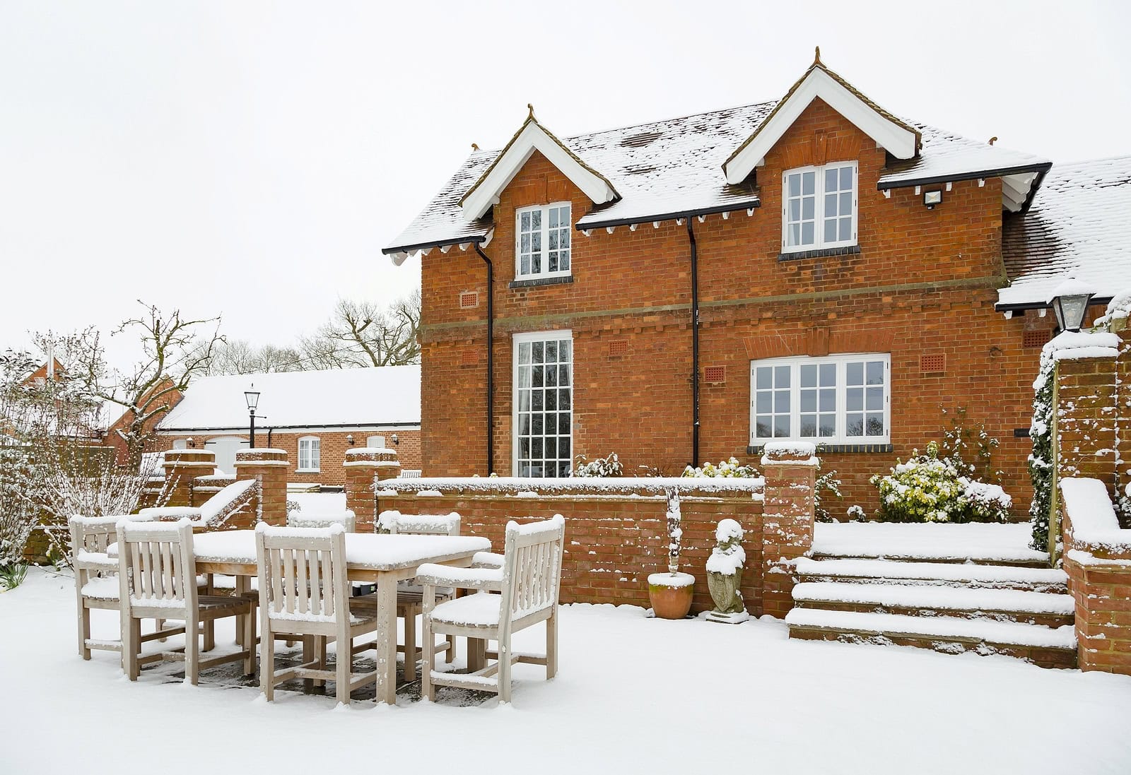 Historic brick house with snow-covered outdoor patio and masonry details.