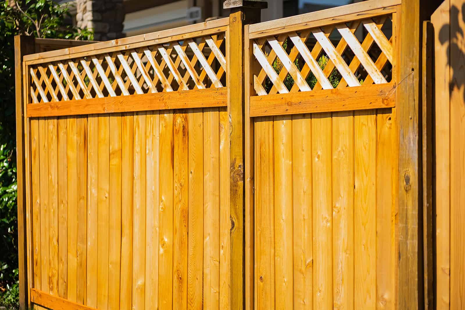Beautiful wooden fence with decorative lattice top, showcasing craftsmanship and outdoor design.