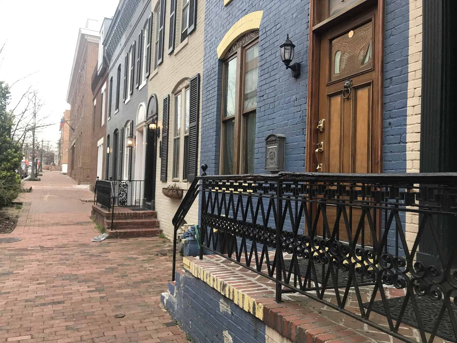 Historic brick row houses with detailed masonry and black wrought iron railings.