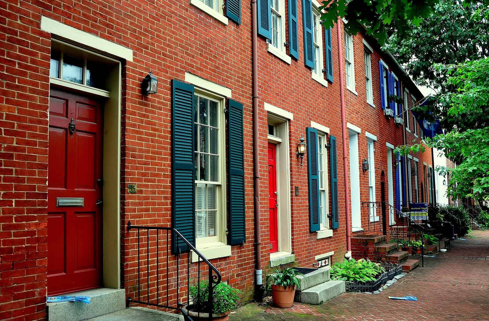Historic brick row houses with detailed masonry and vibrant blue shutters.