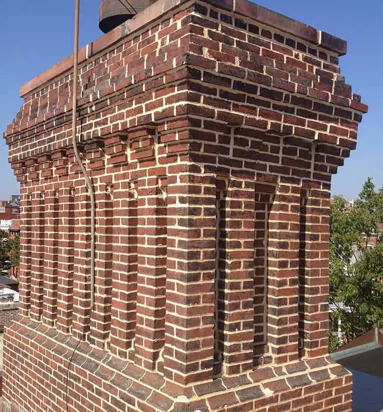 Historic brick chimney with detailed masonry and tuckpointing work.