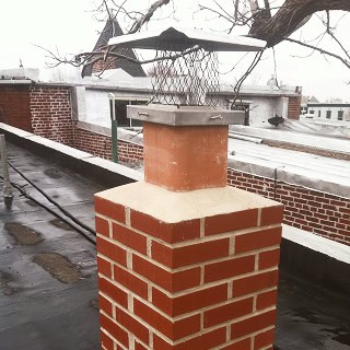 Restoration of historic masonry with precise tuckpointing on a rooftop chimney.