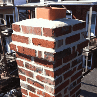 Restoration of historic masonry and tuckpointing on a brick chimney.