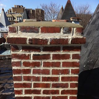 Close-up of historic brick chimney with detailed tuckpointing work.