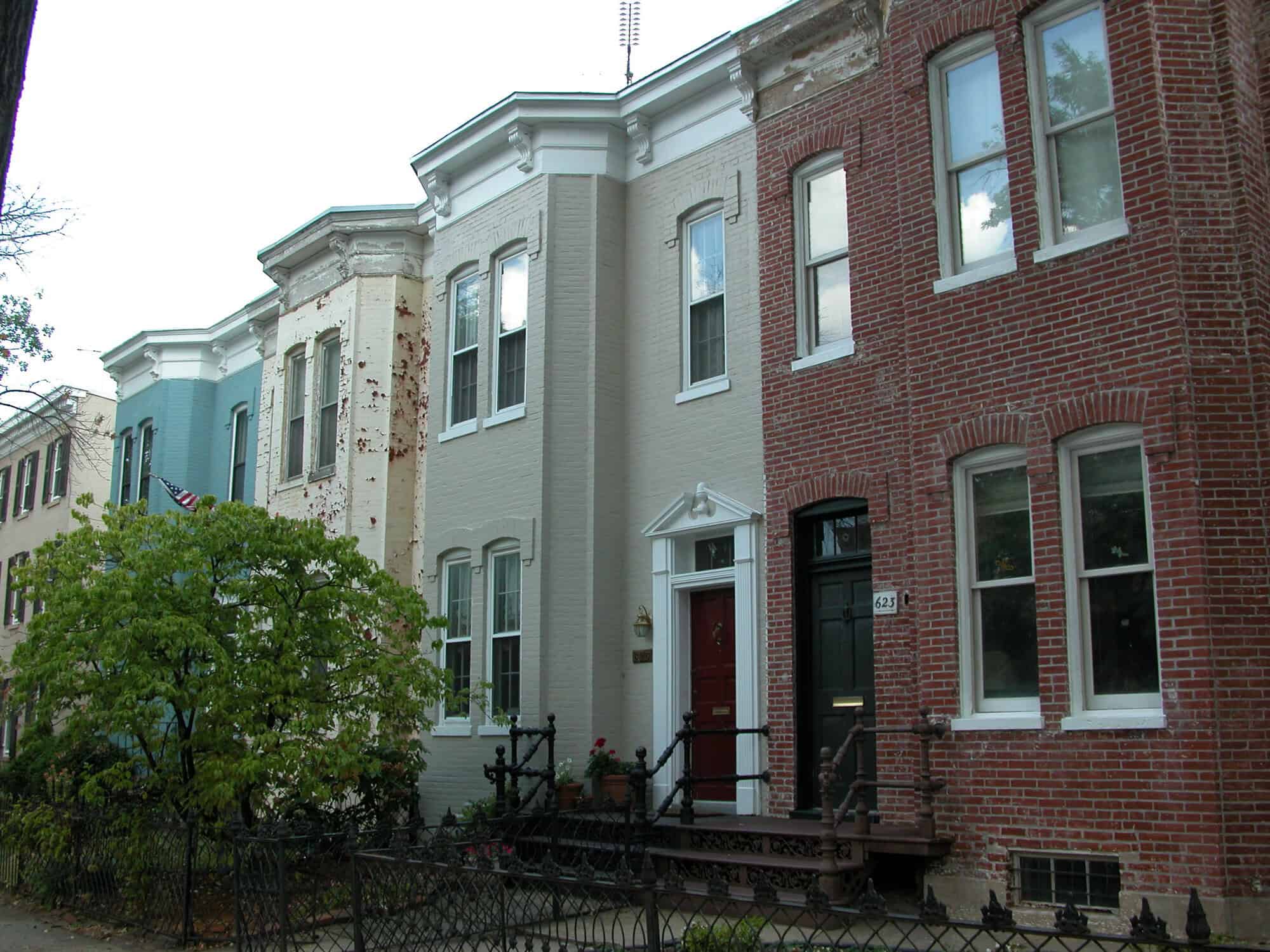 Historic row houses with restored brick and masonry work in a city neighborhood.