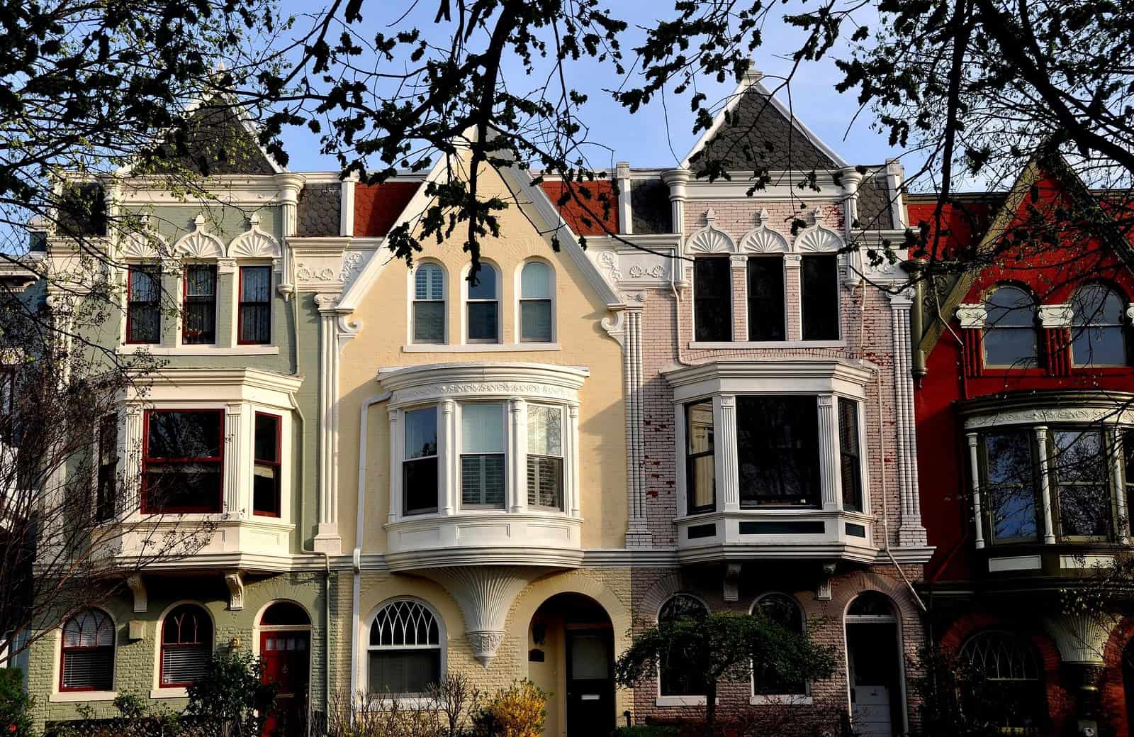 Row of historic Victorian houses with detailed masonry and colorful facades in a residential neighbo.