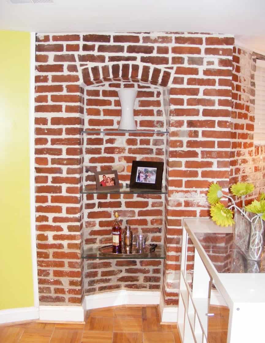 Archway with exposed brickwork and decorative niche.