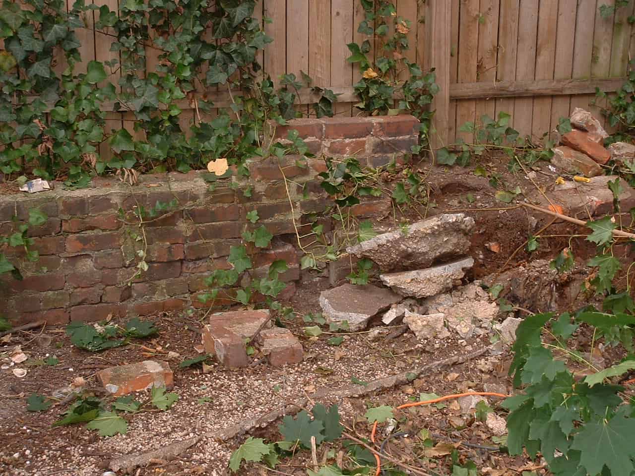 Close-up of historic brick masonry wall with tuckpointing and damaged sections.