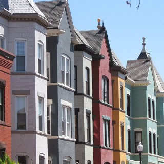 Colorful Victorian-style brick row houses with detailed masonry work and decorative trim.