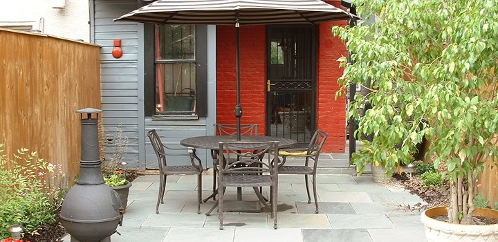 Outdoor patio with table and chairs in a renovated historic masonry setting.