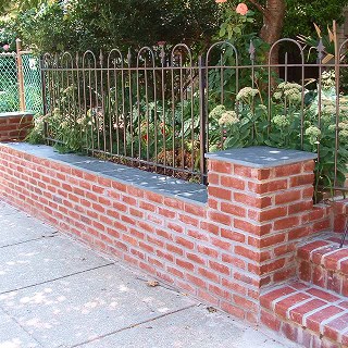 Historic masonry and tuckpointing work on a brick garden wall.