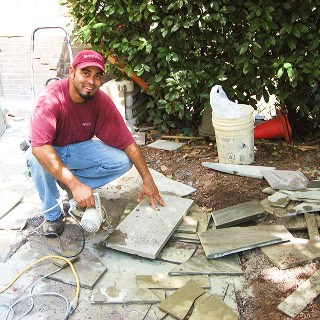 Mason working on historic masonry and tuckpointing project outdoors.