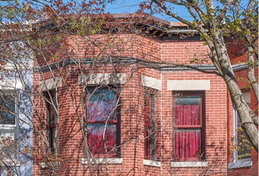 Historic brick building with masonry and tuckpointing work in progress.