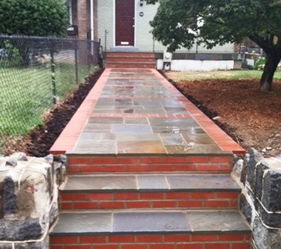 Beautifully restored brick and stone masonry walkway with steps, showcasing historic craftsmanship.