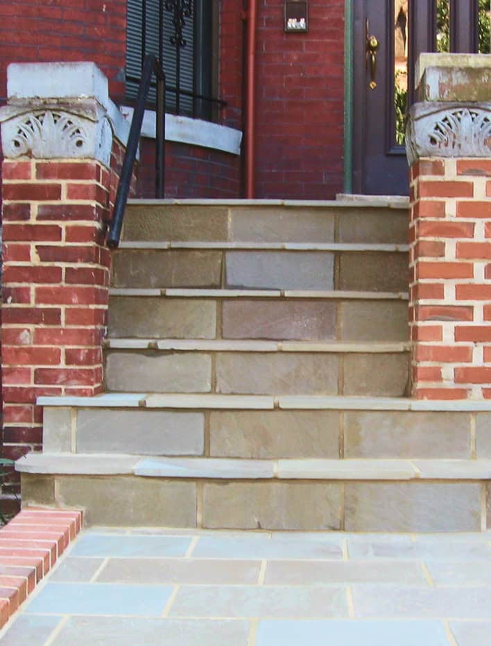 Close-up of historic brick and stone masonry steps with decorative concrete accents.