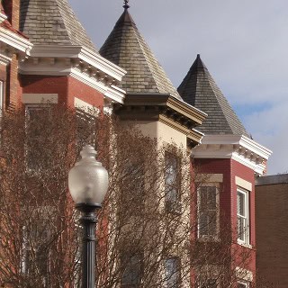 Restoration of historic masonry and tuckpointing on Renaissance-style building with turrets.