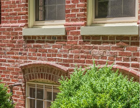 Close-up of historic brick masonry with tuckpointing on a building facade.