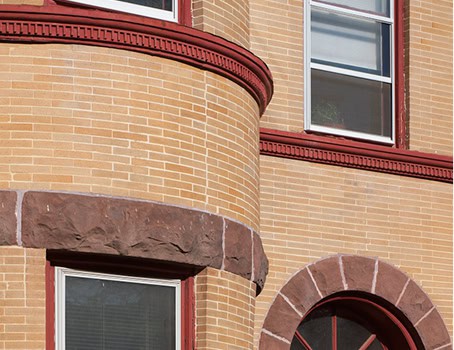 Close-up of historic masonry and tuckpointing on a brick building facade.