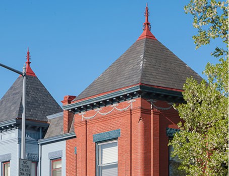 Close-up of historic brick building with detailed masonry and decorative roof elements.