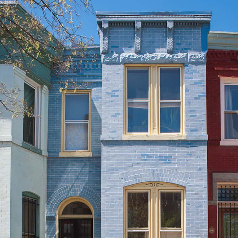 Detailed image of a historic brick building with blue masonry and decorative architectural elements.