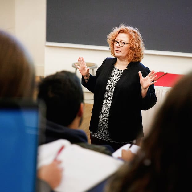 Woman giving a lecture on Renaissance development and historic masonry techniques to students.