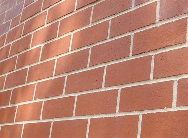 Close-up of historic brick masonry with tuckpointing work on a building wall.