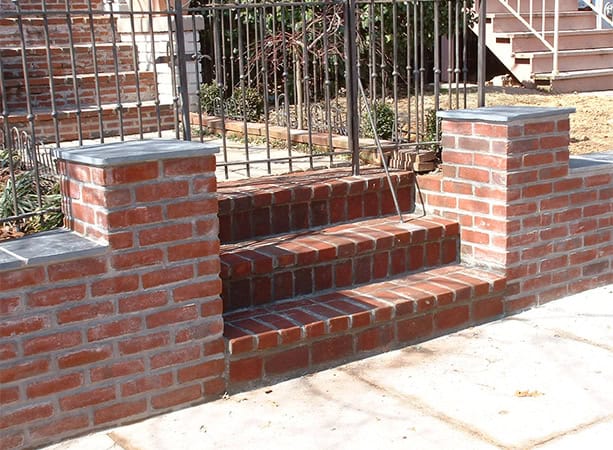 Restored brick steps with historic masonry and tuckpointing on a residential property.