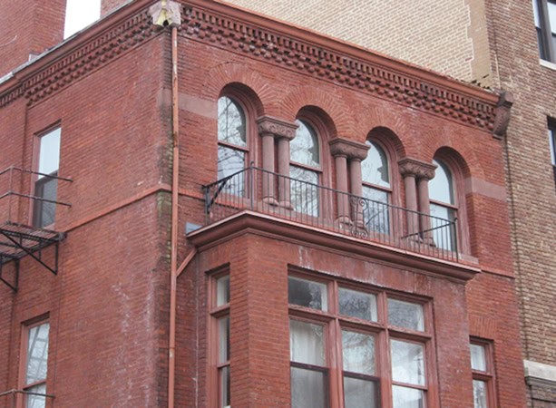 Historic brick building with arched windows and decorative masonry details.